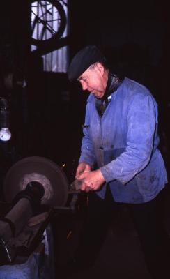 Dorpssmid slijpt op slijpsteen, Lembeke