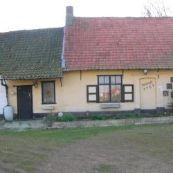 Foto van man en vrouw op het erf met kippen en katten