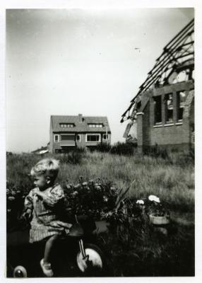 Kleuter op driewieler bij vernielde Sint-Barbarakerk, 1944