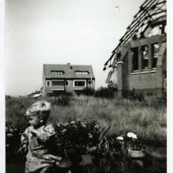 Kleuter op driewieler bij vernielde Sint-Barbarakerk, 1944