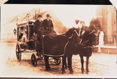 Foto van een lijkkoets getrokken door 2 paarden