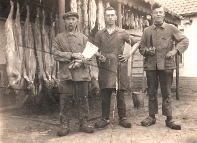 Foto van 3 mannen die poseren voor geslachte dieren.