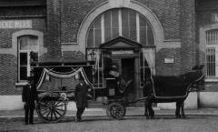Foto van een lijkkoets getrokken door 2 paarden