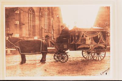 Foto van een lijkkoets getrokken door 2 paarden